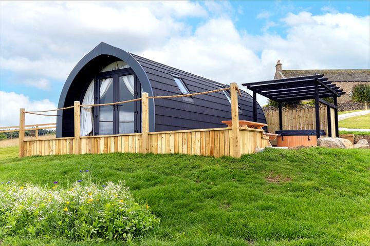 Pod exterior with pergola and hot tub